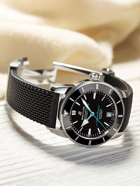 {generated} Breitling Superocean Heritage avec cadran noir et bracelet texturé posé sur une surface claire pour une présentation raffinée