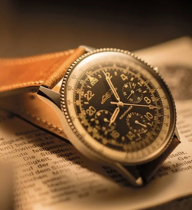 {generated} 1962年復古Breitling Navitimer在暖光下呈現黑色錶盤、計算尺錶圈與皮革錶帶。