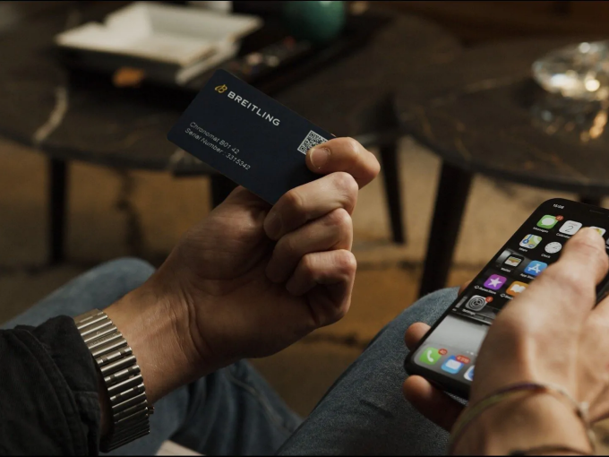 {generated} Hands holding a Breitling warranty card and smartphone, highlighting the activation process in a relaxed indoor setting.