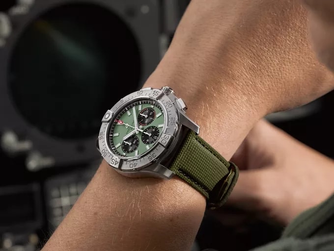 {generated} 佩戴綠色錶盤與錶帶的Breitling Avenger B01 Chronograph 44，在駕駛艙儀表旁展現鮮明的航空風格