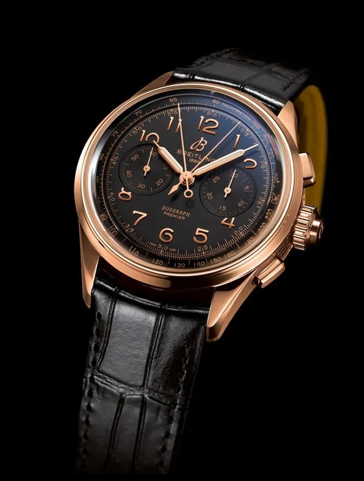 {generated} Breitling Premier Duograph con cassa in oro rosa, quadrante nero e cinturino in pelle nera su sfondo scuro.