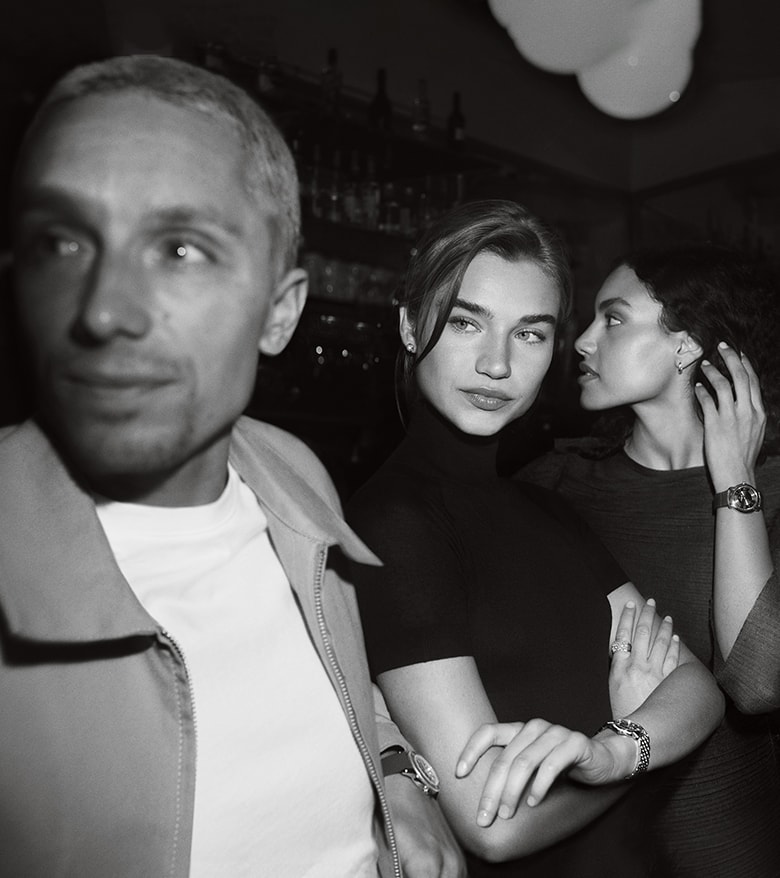 {generated} 女性たちが夜のシーンで腕を組みながら、エレガントで洗練されたスタイルのBreitling Lady Premierを際立たせる。