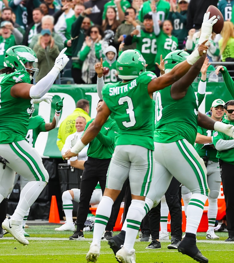 {generated} Philadelphia Eagles players celebrate a big play on the field as cheering fans in green fill the stadium backdrop.