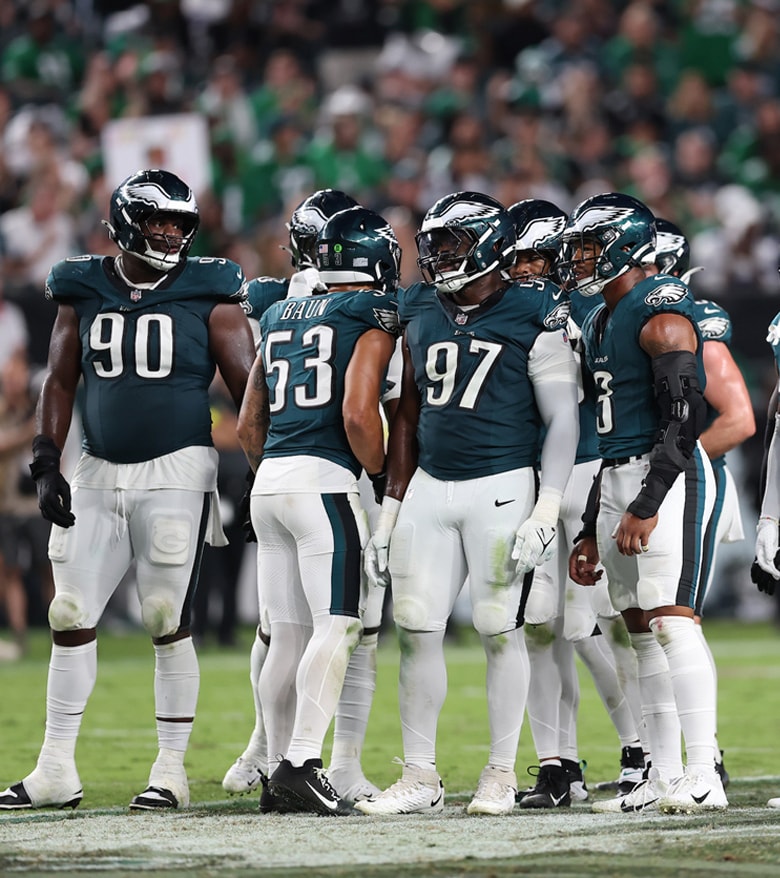 {generated} Philadelphia Eagles players celebrate a major play on the field as cheering fans in green fill the stadium backdrop.