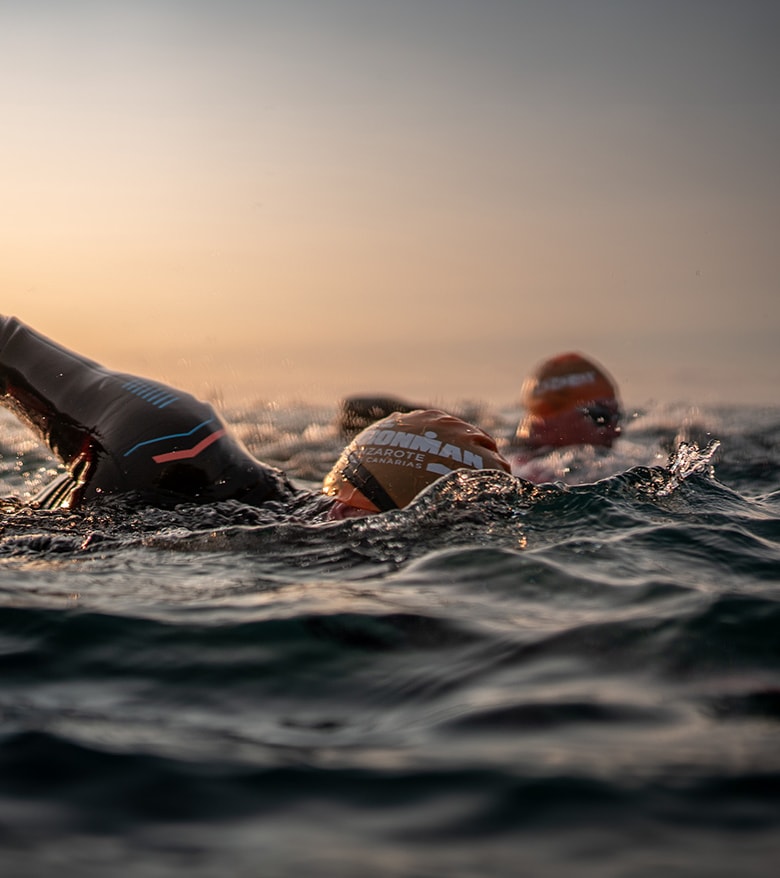 Deux athlètes Ironman, symbolisant le partenariat entre Breitling et Ironman, se jettent à l'eau.