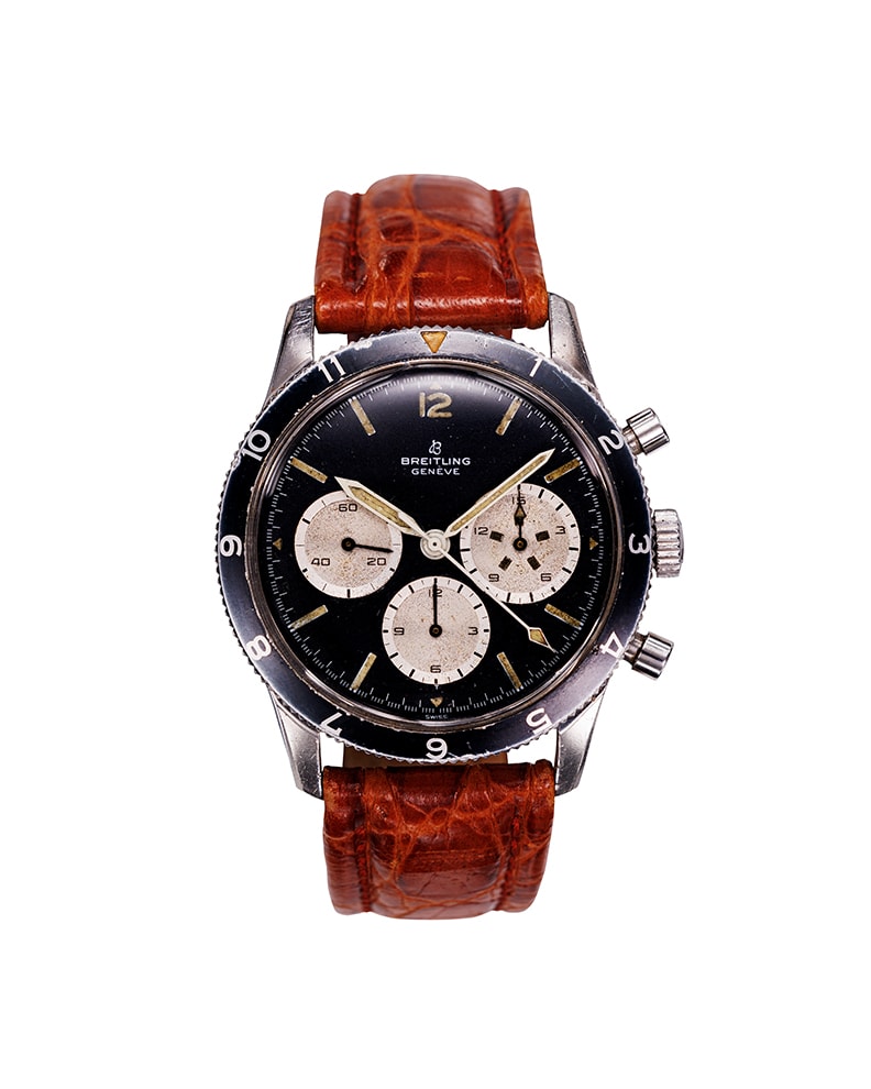 {generated} Breitling Co-Pilot watch featuring a vintage black dial, three cream subdials, and a brown leather strap viewed front-on.