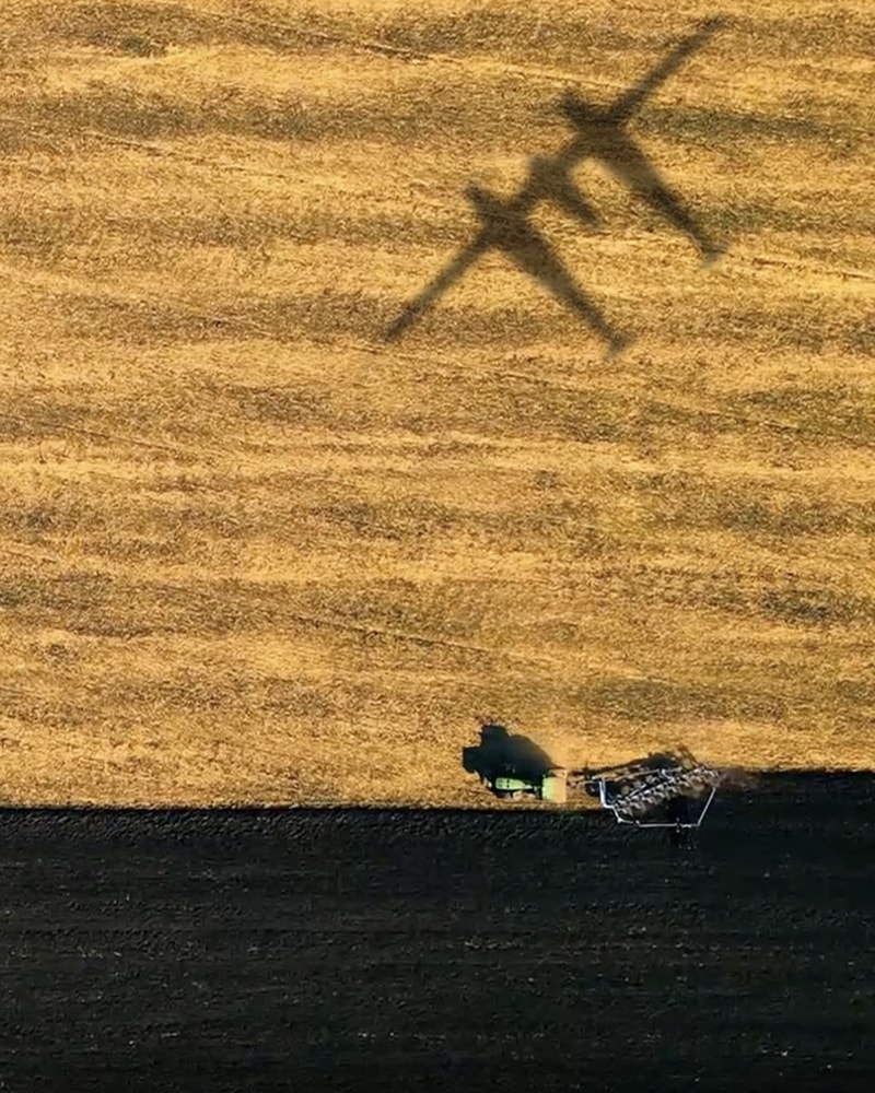 {generated} 飛機陰影掠過金色田野，拖拉機耕作黑土，呼應Climate Impulse的環保願景