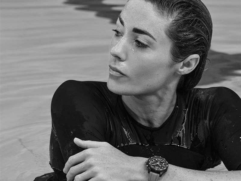 {generated} 一位運動員在水中休息，Breitling運動錶帶腕錶在其濕潤上衣上格外醒目