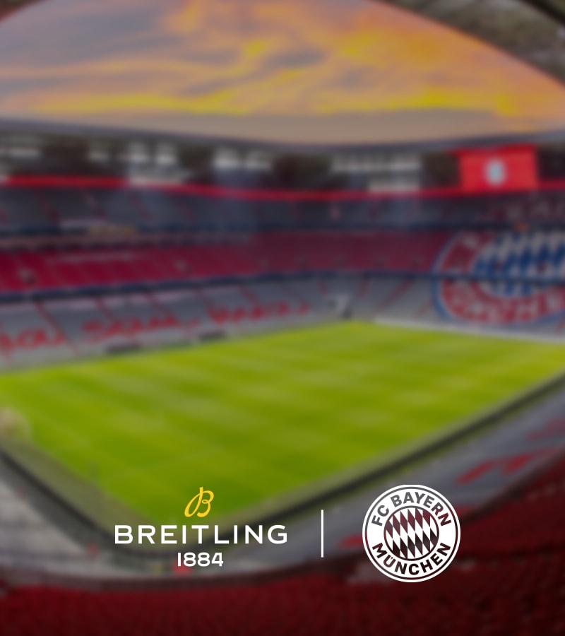 {generated} A blurred football stadium backdrop framing centred Breitling and FC Bayern logos highlighting their partnership.