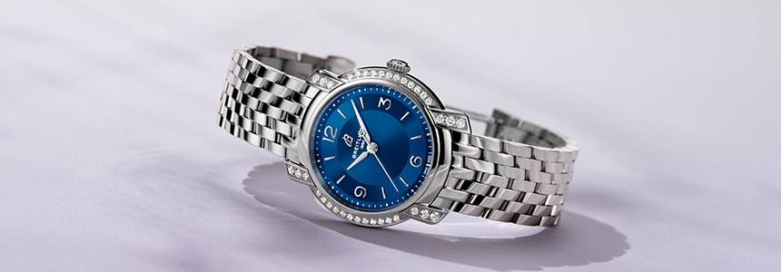 {generated} Breitling diamond-set watch with blue dial and polished steel bracelet displayed against a clean light background
