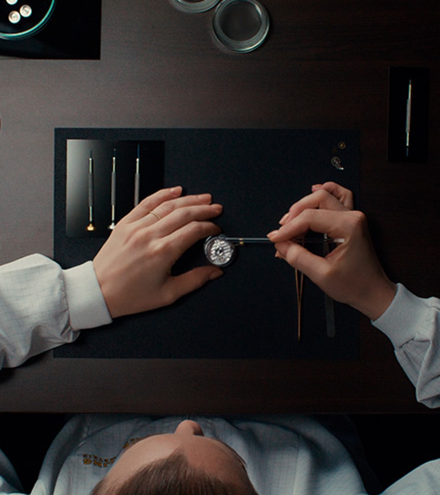 {generated} Ein Breitling Techniker montiert sorgfältig ein Uhrwerk mit Präzisionswerkzeugen und zeigt dabei höchste Servicehandwerkskunst.