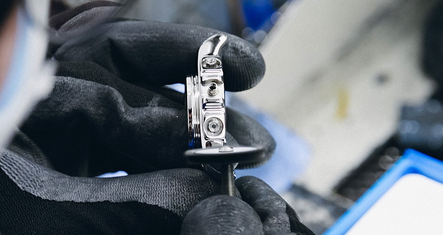 {generated} Gloved hands carefully inspecting a polished Breitling watch case during exterior maintenance in a precise workshop setting