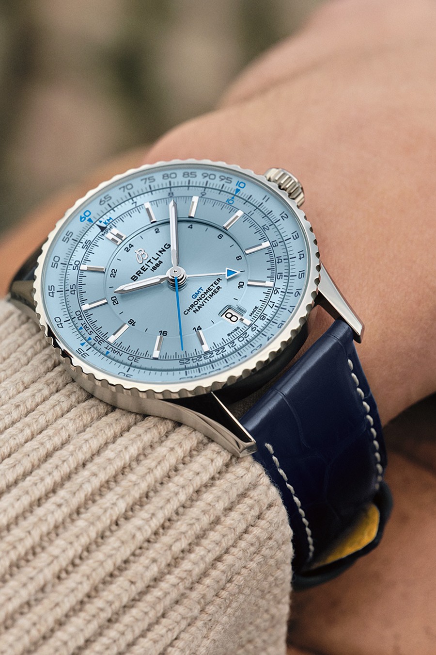 {generated} Breitling Navitimer GMT con esfera azul clara y correa de cuero azul en la muñeca, mostrando sus detalles precisos