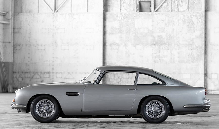 {generated} 灰色阿斯頓馬丁跑車搭配紅色細節置於燈光下，展現其與Breitling的合作關係。