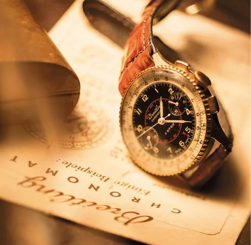 {generated} 1940款Breitling復古計時碼錶以黑色錶盤和棕色皮革錶帶呈現，置於舊文件上，在暖光中展現經典格調與年代質感，營造濃厚歷史氛圍與精緻工藝魅力，突顯腕錶獨特風格與品牌傳承風采