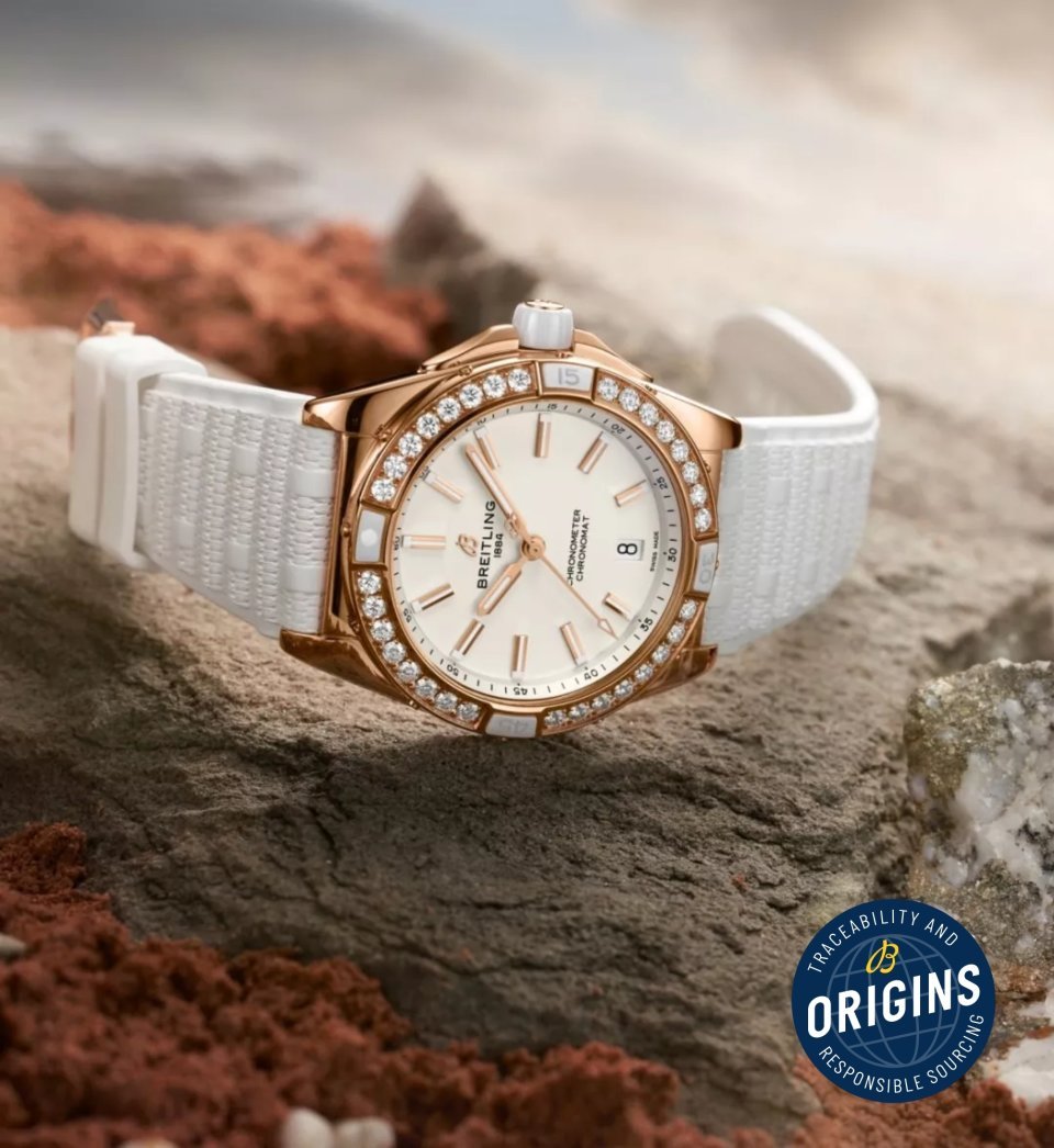 {generated} Breitling Chronomat Origins watch in rose gold with diamond bezel and white strap placed on natural rocks evoking sourcing