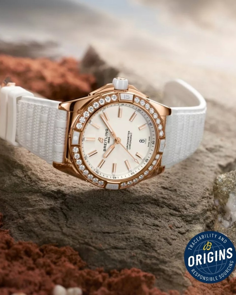 {generated} Breitling Chronomat Origins以玫瑰金鑲鑽錶圈與白色錶帶置於岩石上，呼應其負責任溯源理念