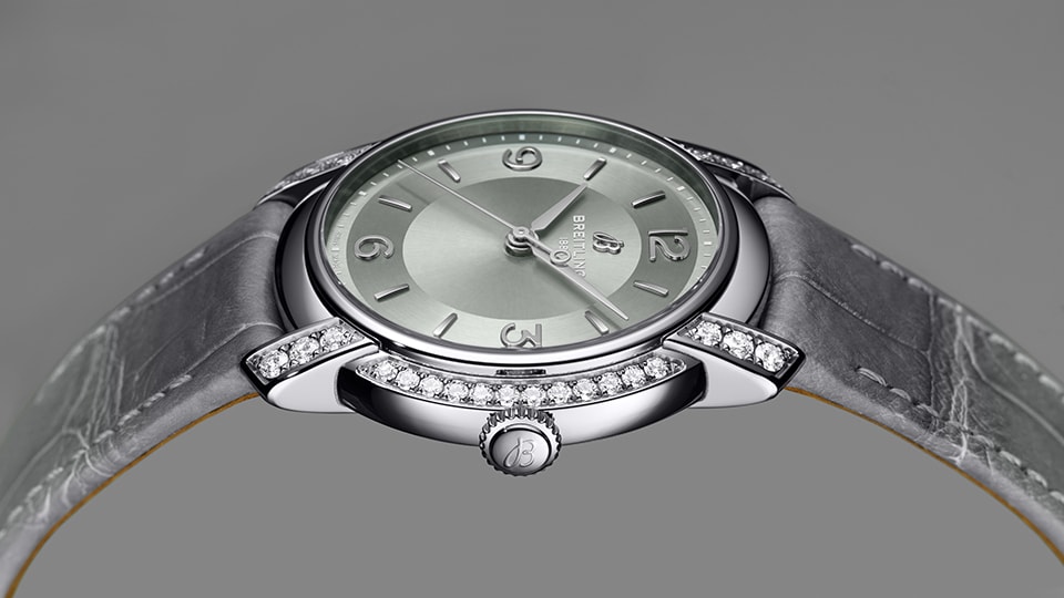 {generated} グリーンダイヤルとダイヤ付きラグ、グレーストラップを備えたBreitling Lady Premierを上品に映すクローズアップ