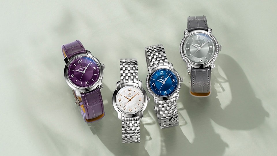 {generated} 부드러운 표면에 놓인 Breitling Lady Premier 여성용 시계가 다채로운 다이얼과 다양한 스트랩을 강조한다.