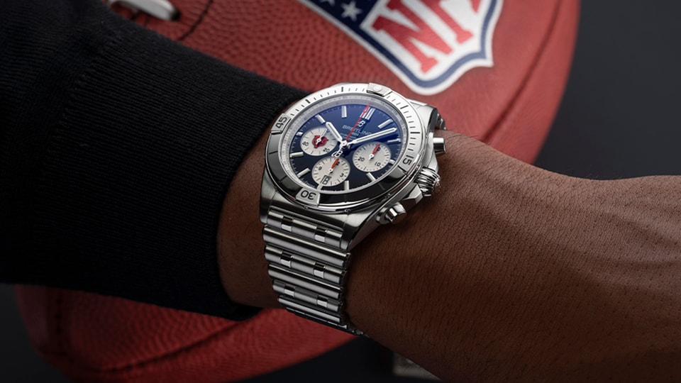 {generated} Breitling Chronomat with blue dial and steel bracelet worn near a Chicago Bears NFL football for team-themed styling