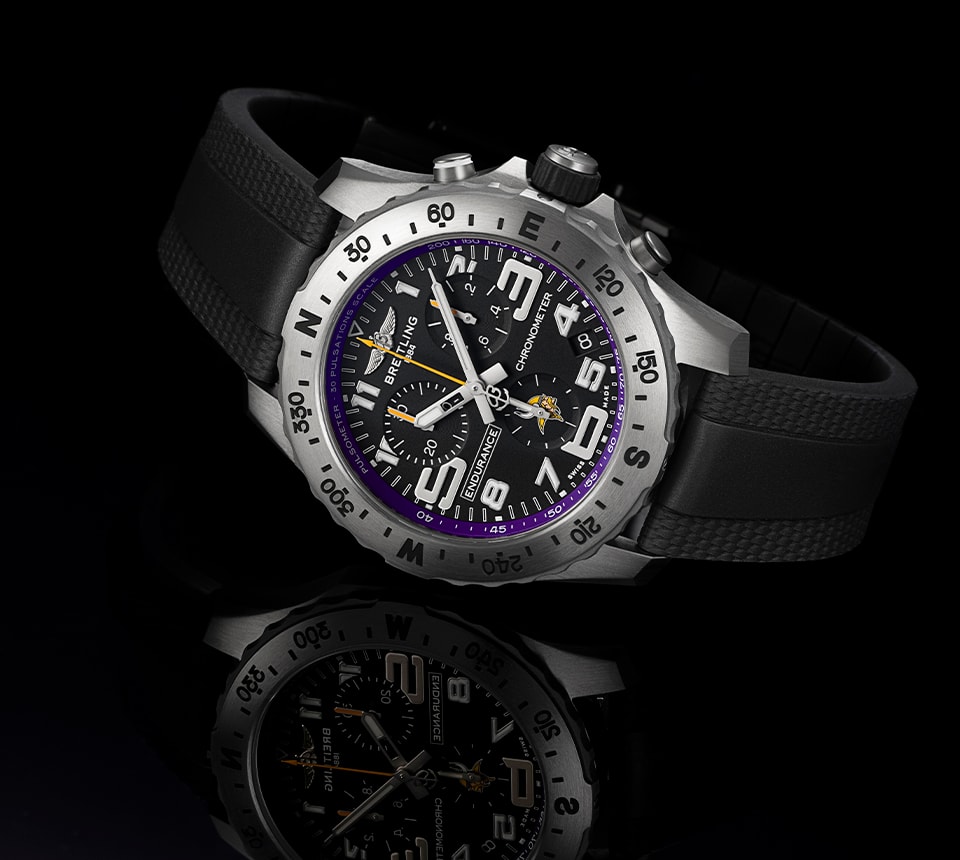 {generated} Breitling Endurance 黑色錶盤搭配紫色維京人細節與黑色錶帶，陳列於深色反射表面上。
