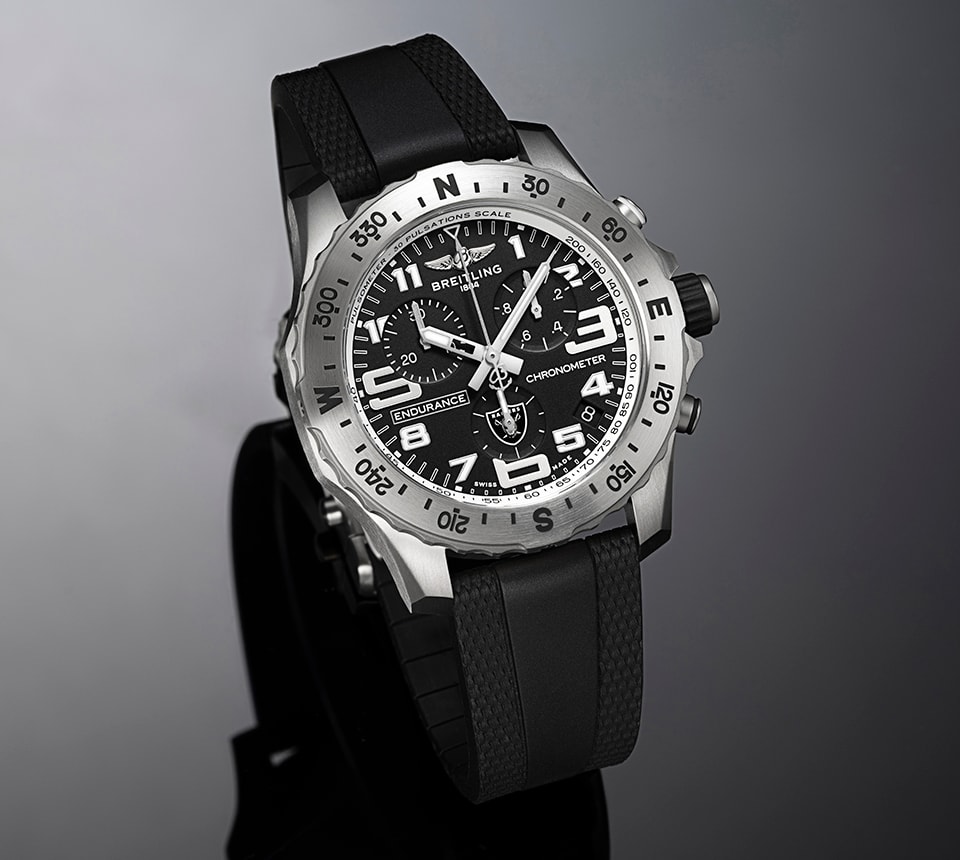 {generated} Breitling Endurance cronômetro com mostrador preto, emblema Raiders e pulseira de borracha exibido em um estúdio elegante