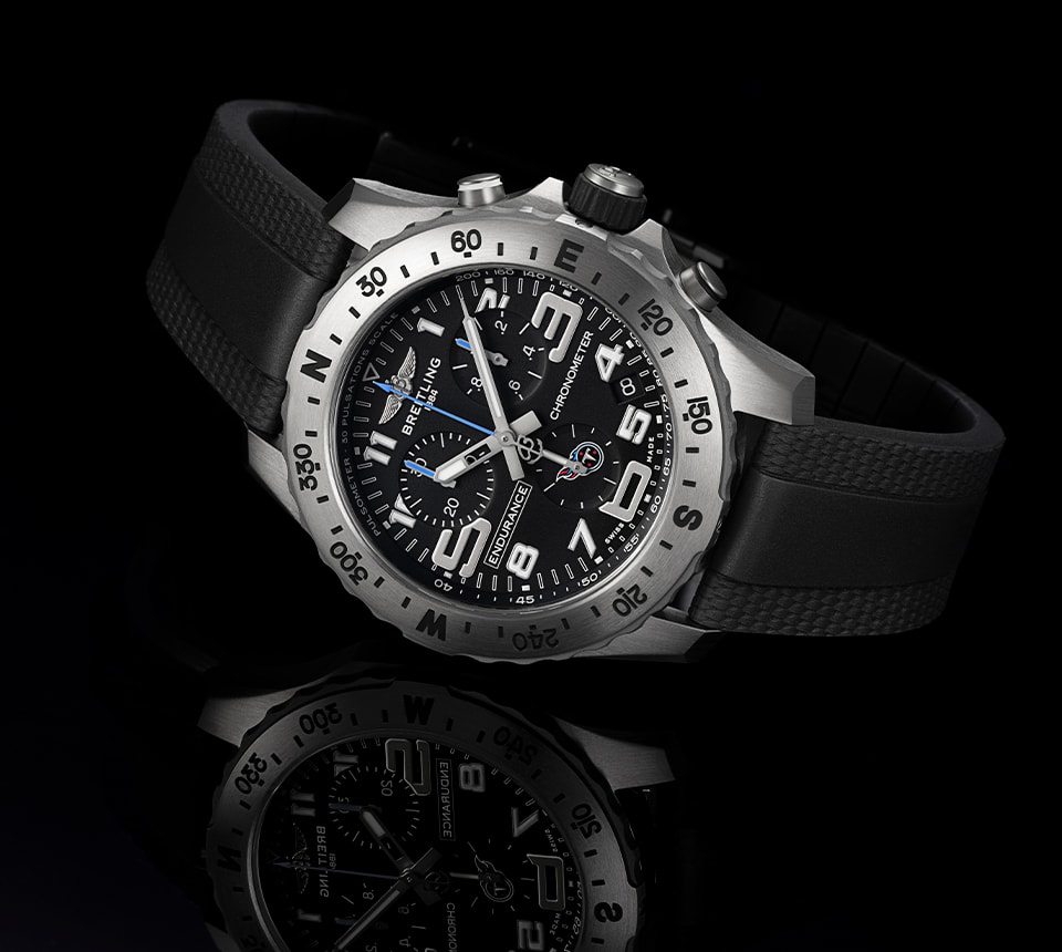 {generated} Breitling Endurance Pro com mostrador preto, números marcantes e detalhe dos Titans exibida em ângulo sobre fundo escuro