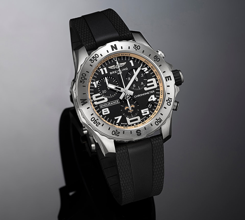{generated} Breitling Endurance watch with black dial and Saints emblem, featuring bold numerals and a black strap on a dark backdrop
