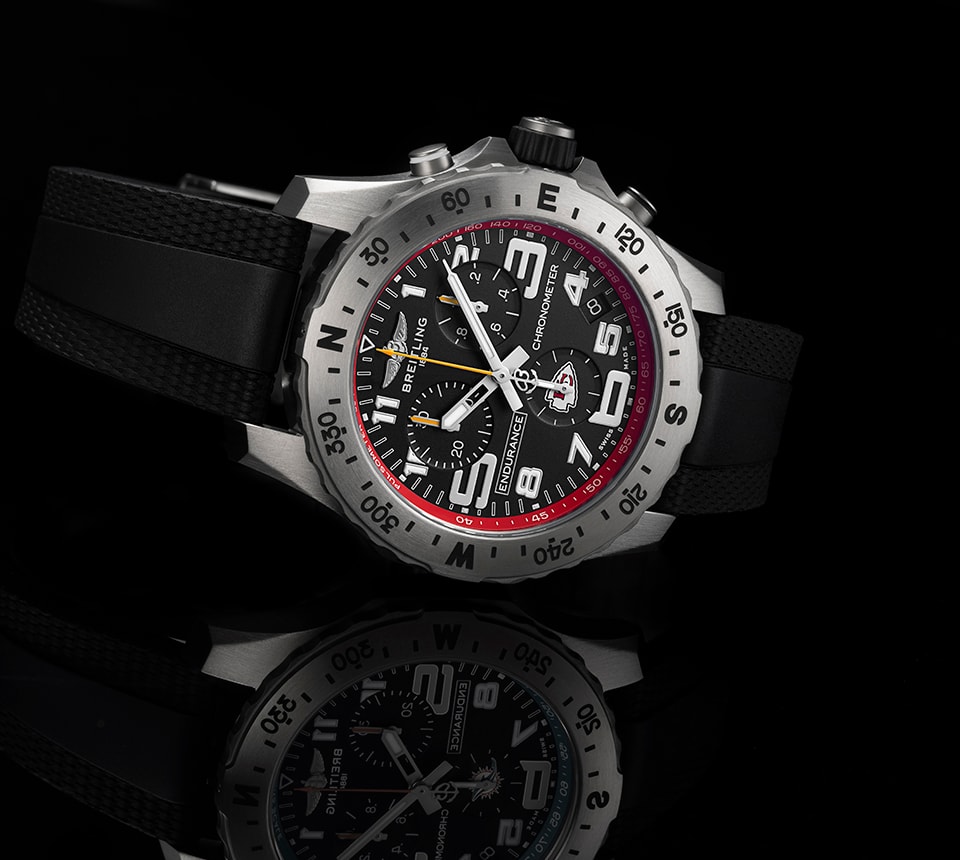 {generated} Breitling Endurance watch with black dial, red Chiefs detailing and rubber strap shown in a reflective studio setting