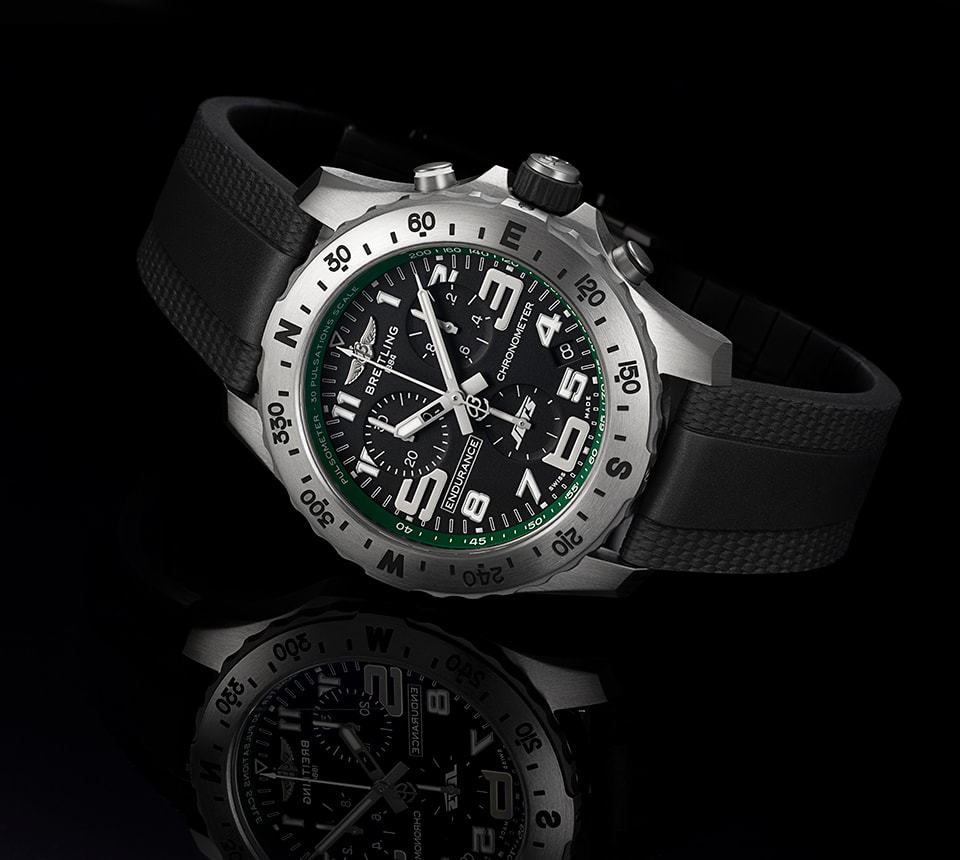 {generated} Breitling Endurance Pro with black dial and green New York Jets accents shown on a dark reflective surface.