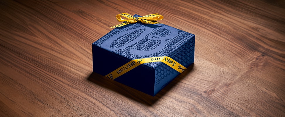 {generated} Breitling gift box in blue with signature yellow Breitling ribbon arranged on a wooden surface for a premium presentation