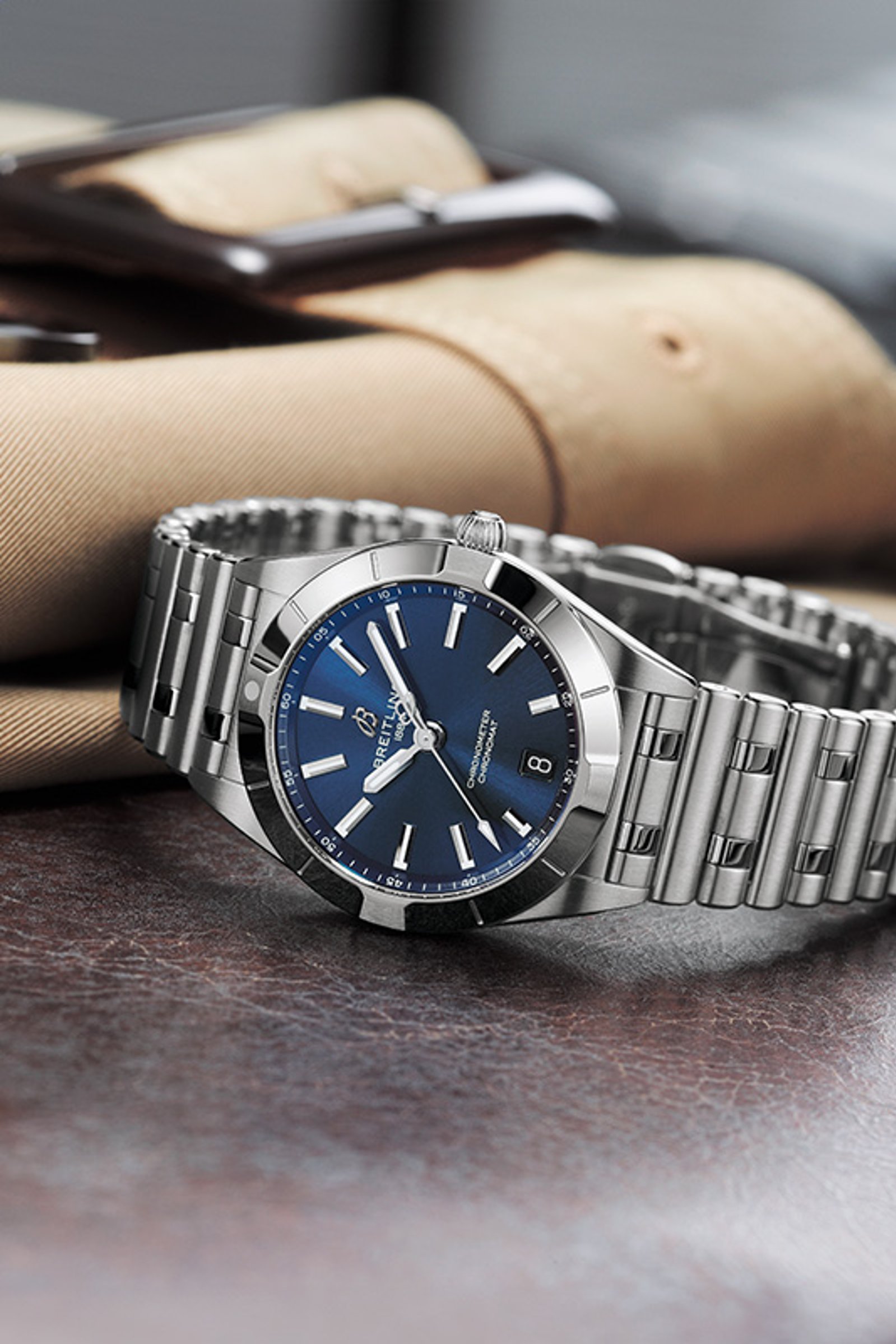 {generated} Breitling Chronomat mit blauem Zifferblatt und Stahlarmband auf Leder arrangiert, als elegantes Geschenk zum Muttertag