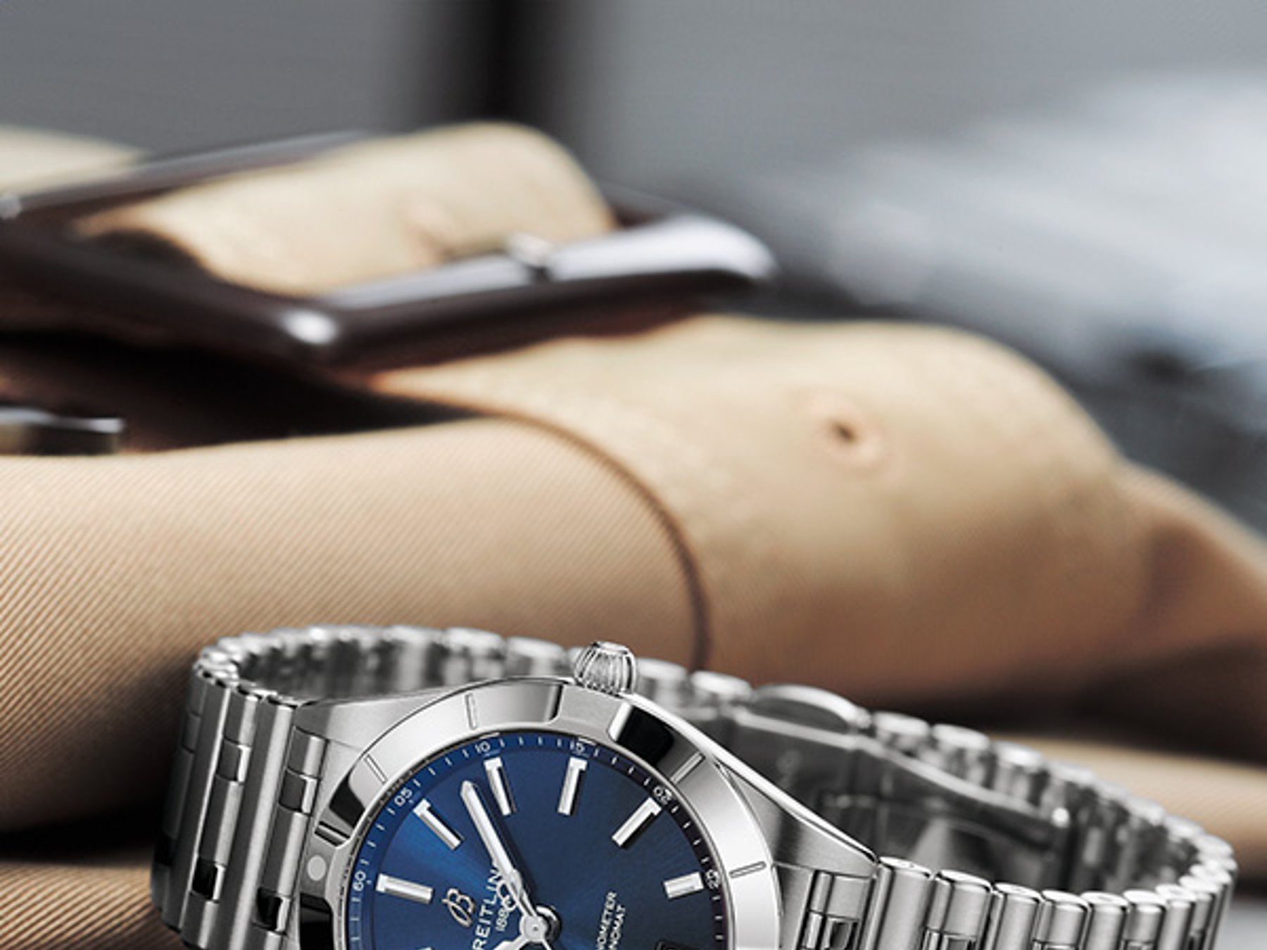 {generated} Breitling Chronomat mit blauem Zifferblatt und Stahlarmband auf Leder arrangiert, als elegantes Geschenk zum Muttertag