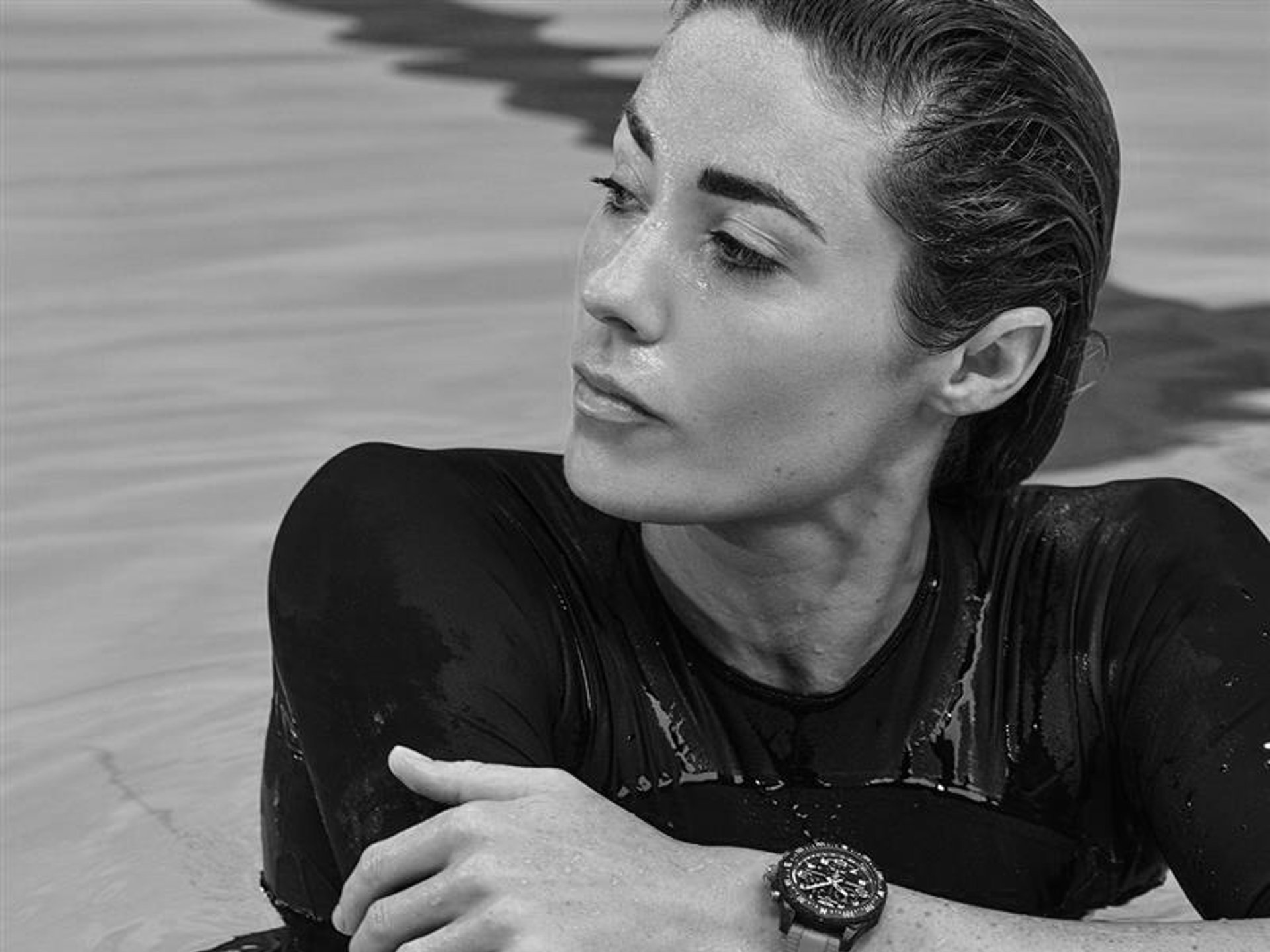 {generated} An athlete resting in water with a Breitling watch on a sporty strap highlighted against a wet performance top