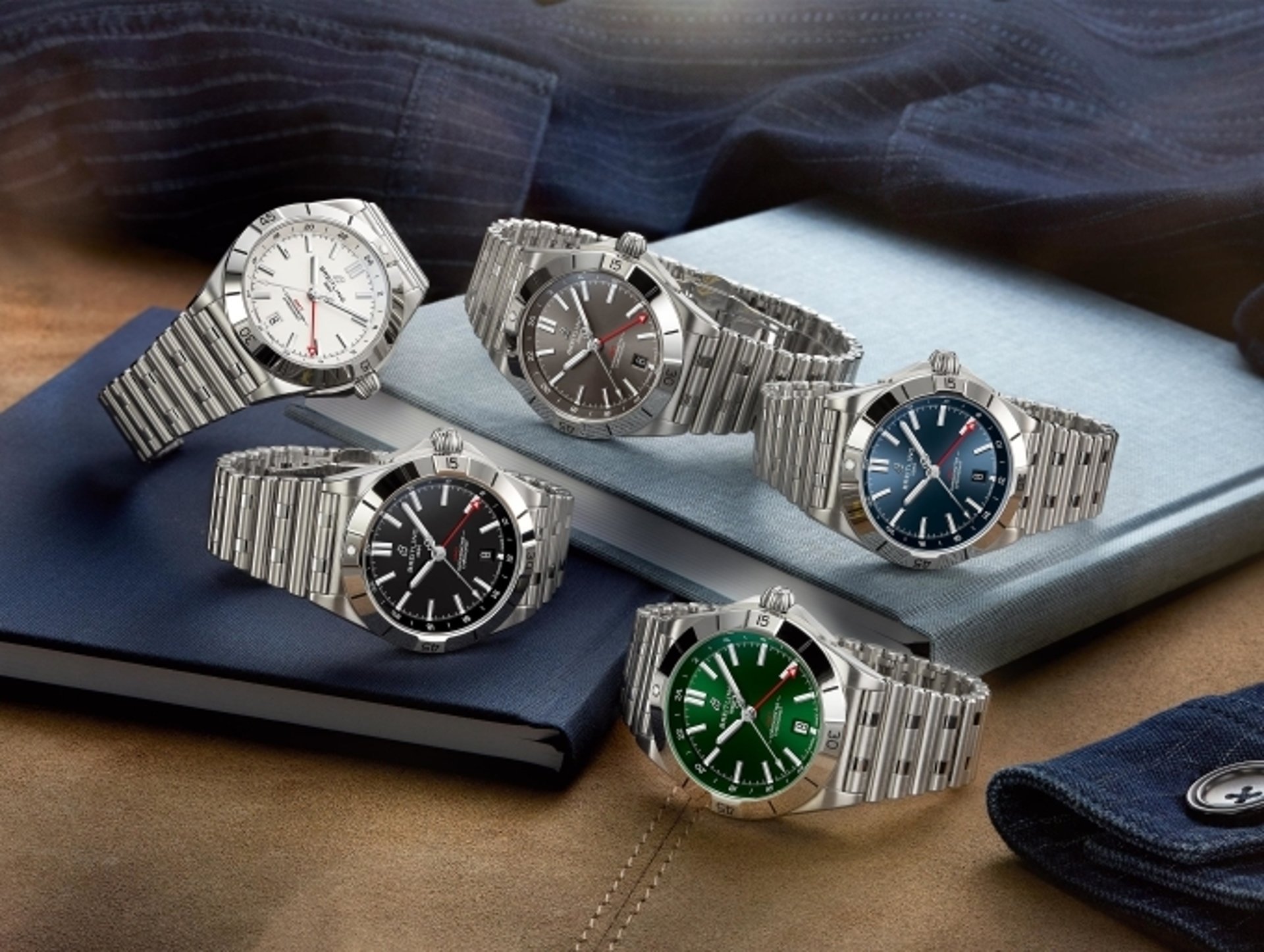 {generated} Breitling Chronomat watches with varied dial colors arranged on fabric and books to showcase their refined design.