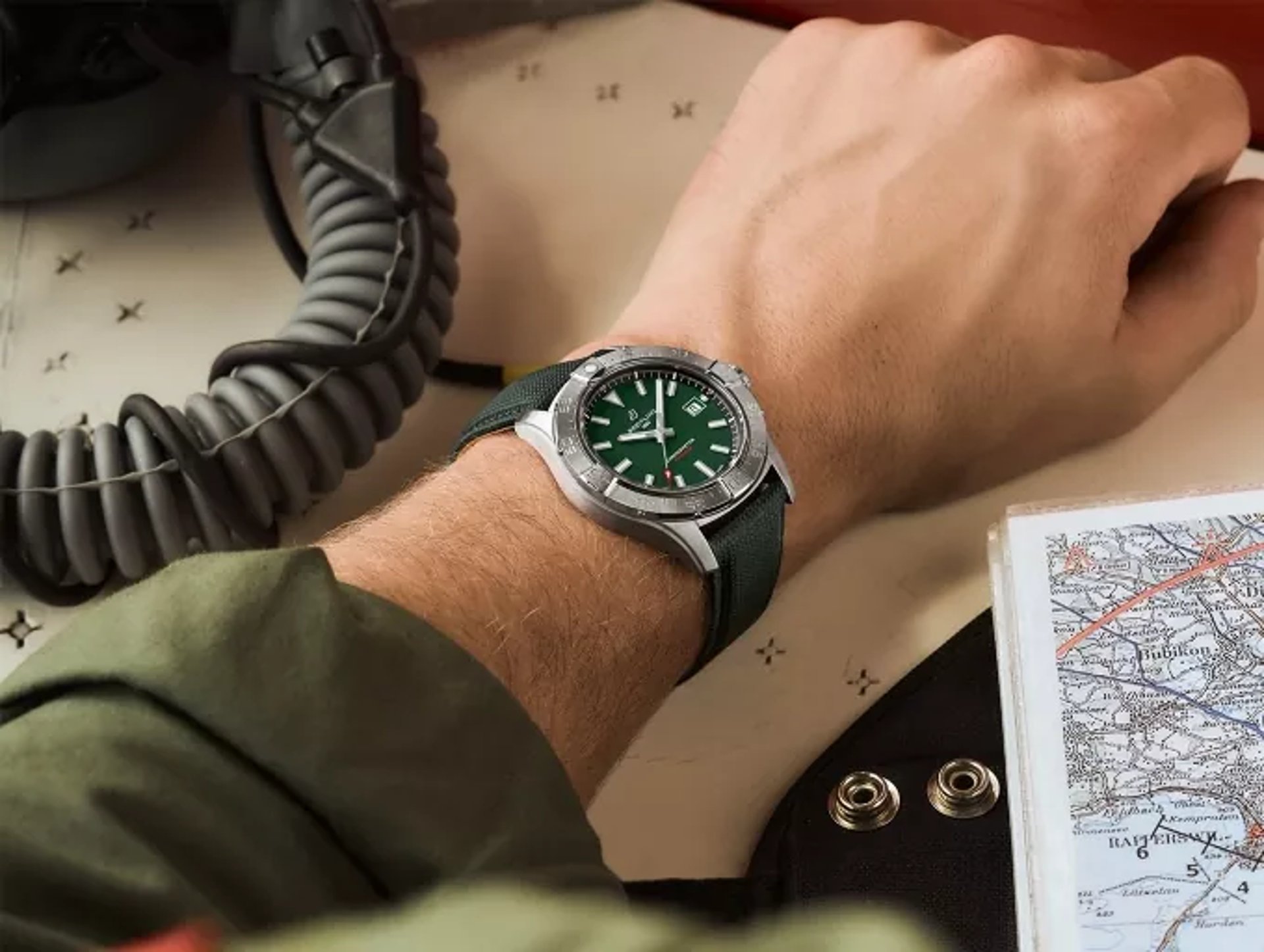 {generated} 航空装備とフライトマップのそばでブライアンリング アベンジャー オートマチック 42 を着用した手首が示される