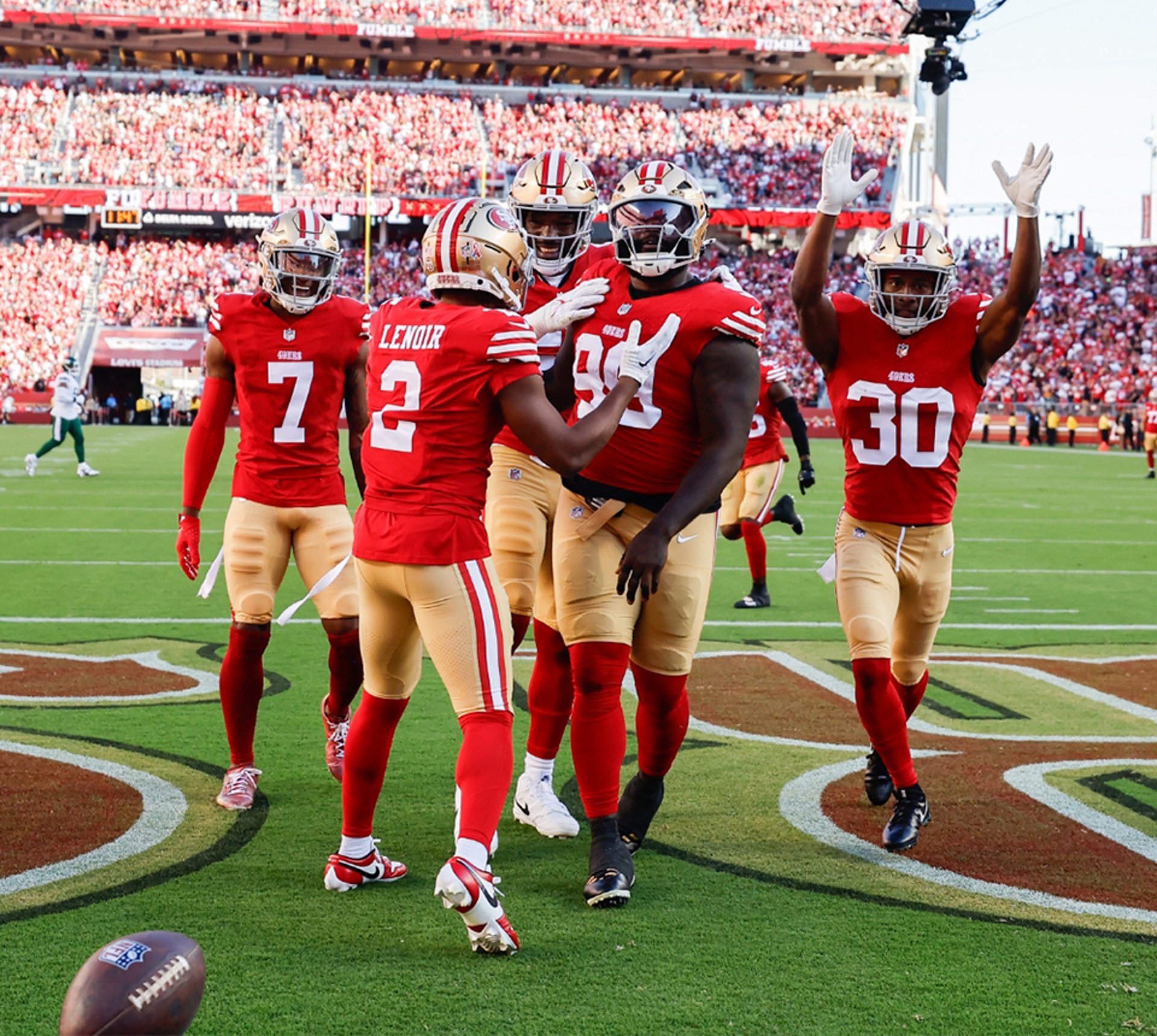 {generated} San Francisco 49ers players celebrate a play on the field amid a packed stadium crowd, highlighting NFL team spirit.