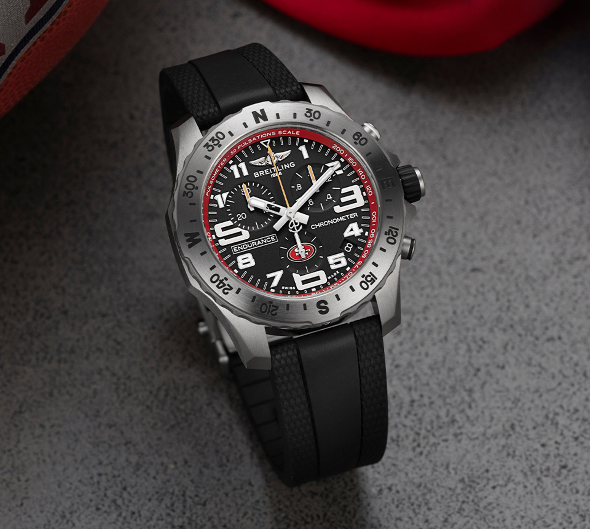 {generated} Reloj Breitling Endurance Pro con esfera negra y detalles rojos 49ers sobre superficie texturada para destacar el producto