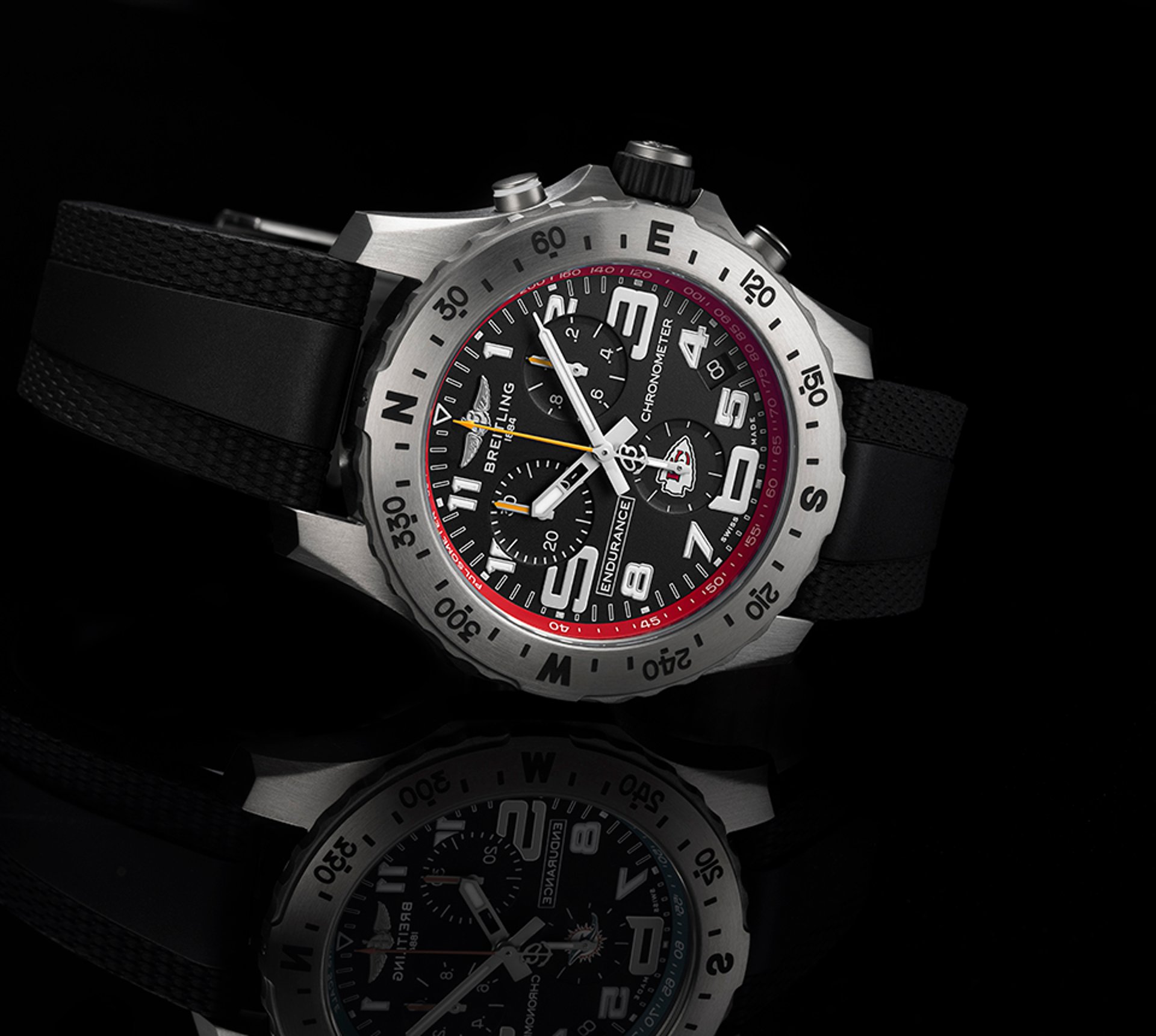 {generated} Breitling Endurance watch with black dial, red Chiefs detailing and rubber strap shown in a reflective studio setting