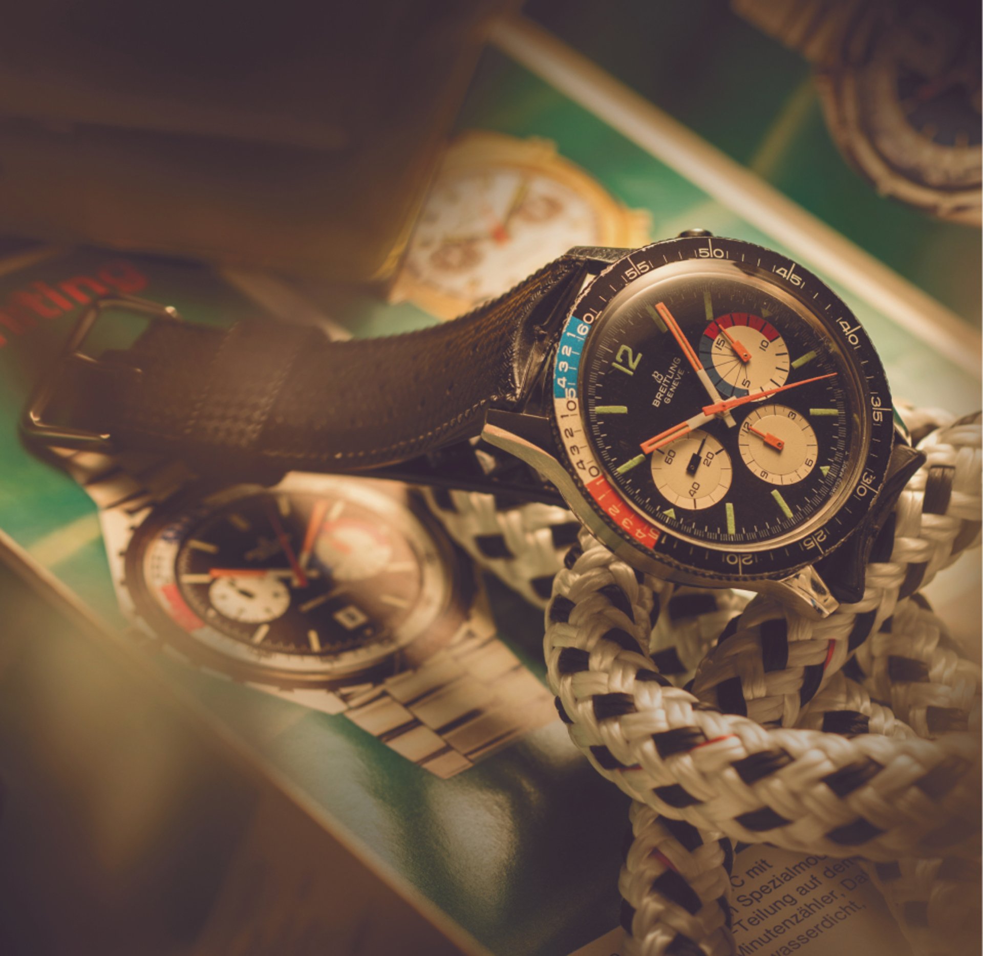 {generated} Breitling watch with a multicolour dial on a leather strap resting over braided rope and vintage imagery in warm light