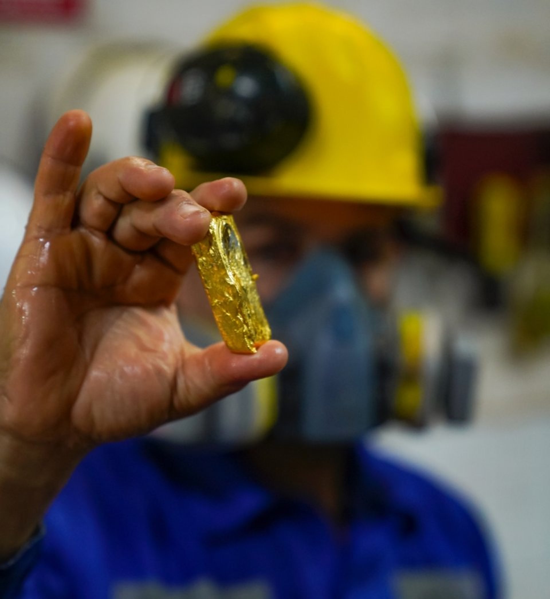 {generated} A worker’s gloved hand holds a small piece of refined gold, underscoring Breitling’s commitment to responsible gold sourcing.