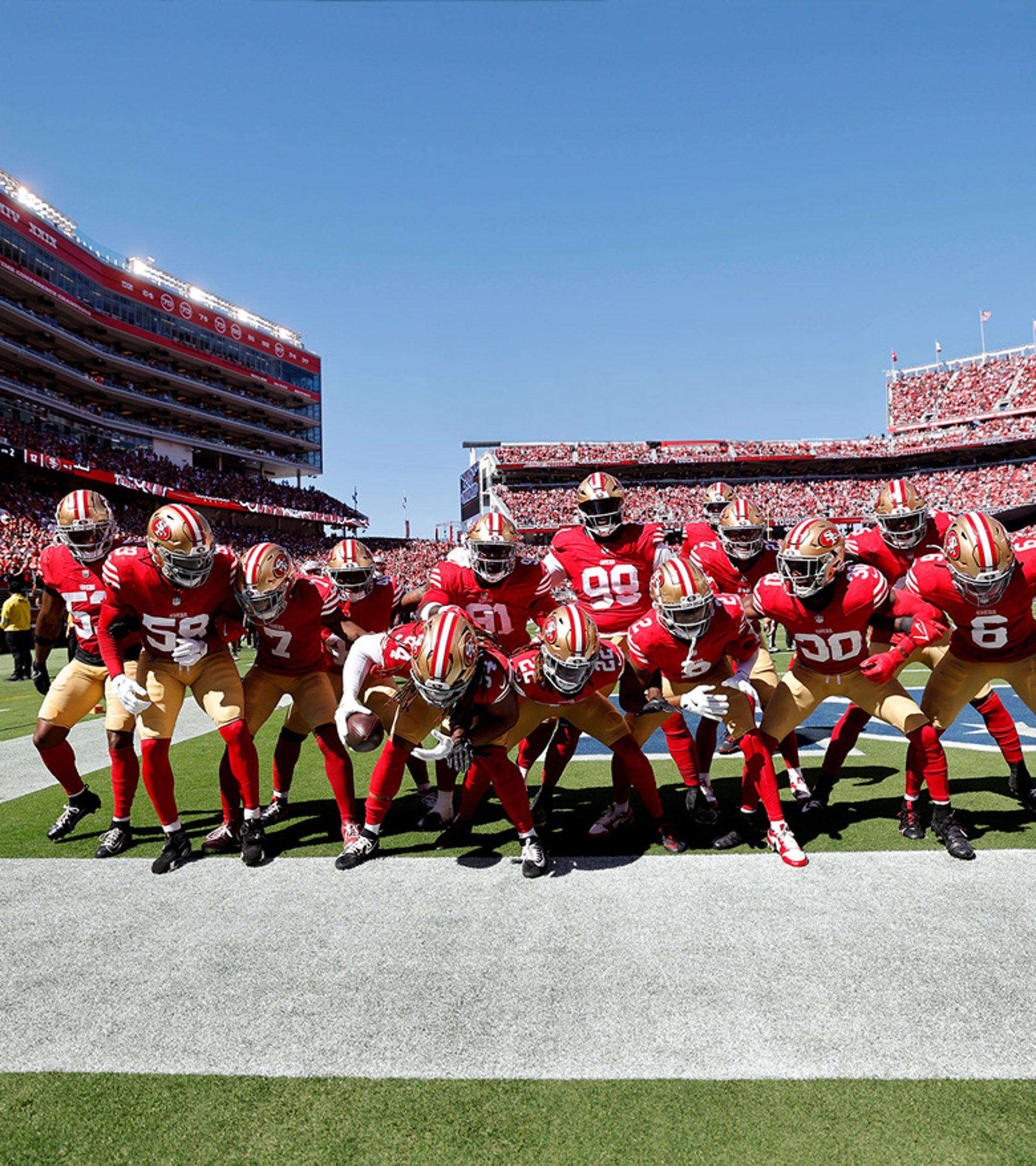 {generated} Jugadores de los San Francisco 49ers unidos en rojo y dorado en el campo, mostrando espíritu de equipo con el vínculo NFL de Breitling