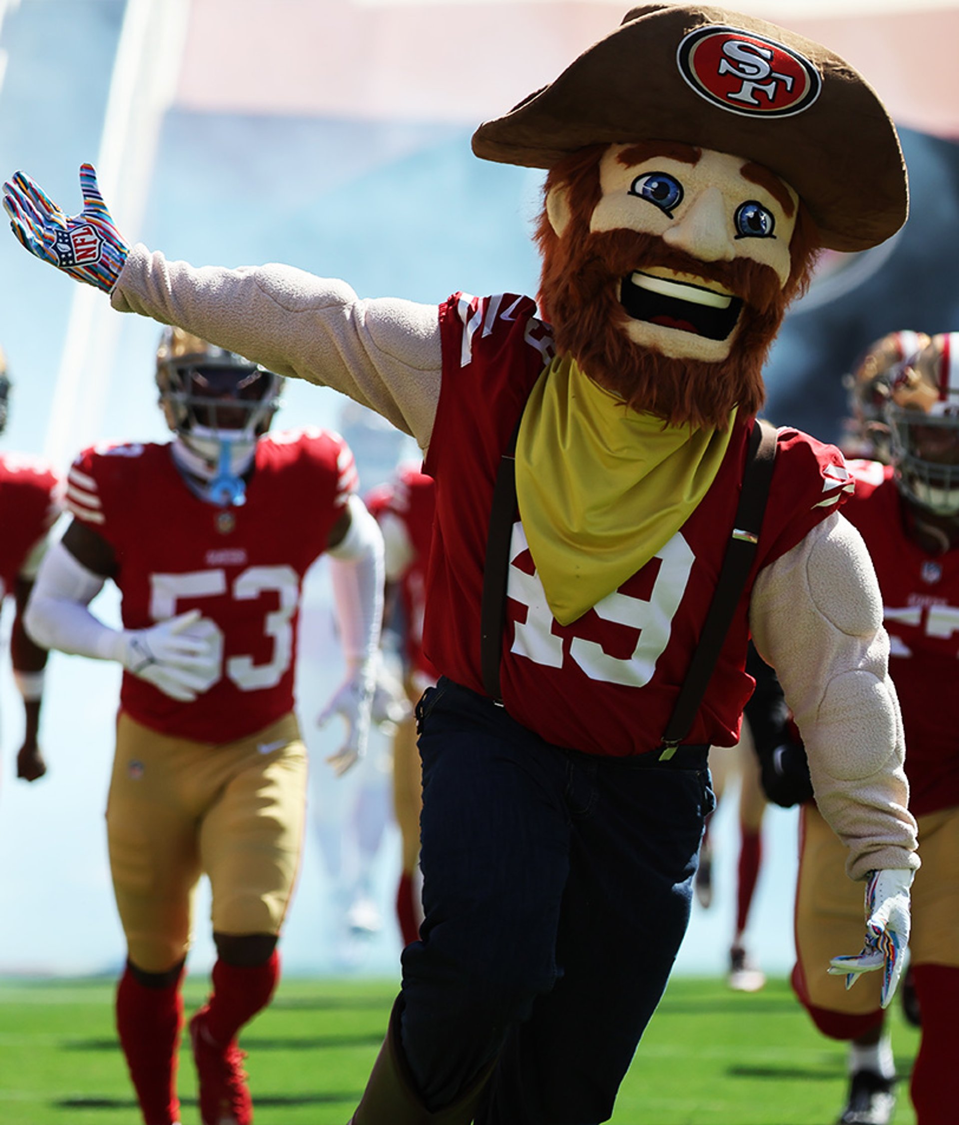 {generated} A football team mascot leads uniformed players onto the field amid bright stadium light and dynamic game-day energy.