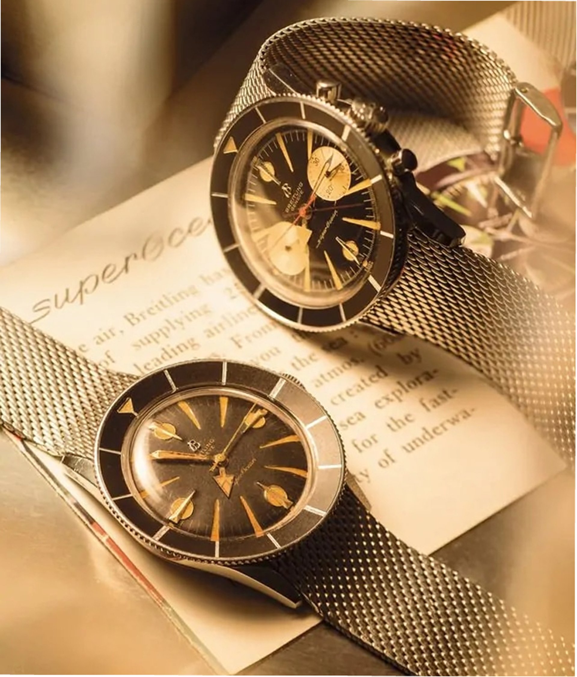 {generated} Two vintage Breitling Superocean watches on mesh bracelets in warm light evoke the brand’s heritage across air, land, sea.