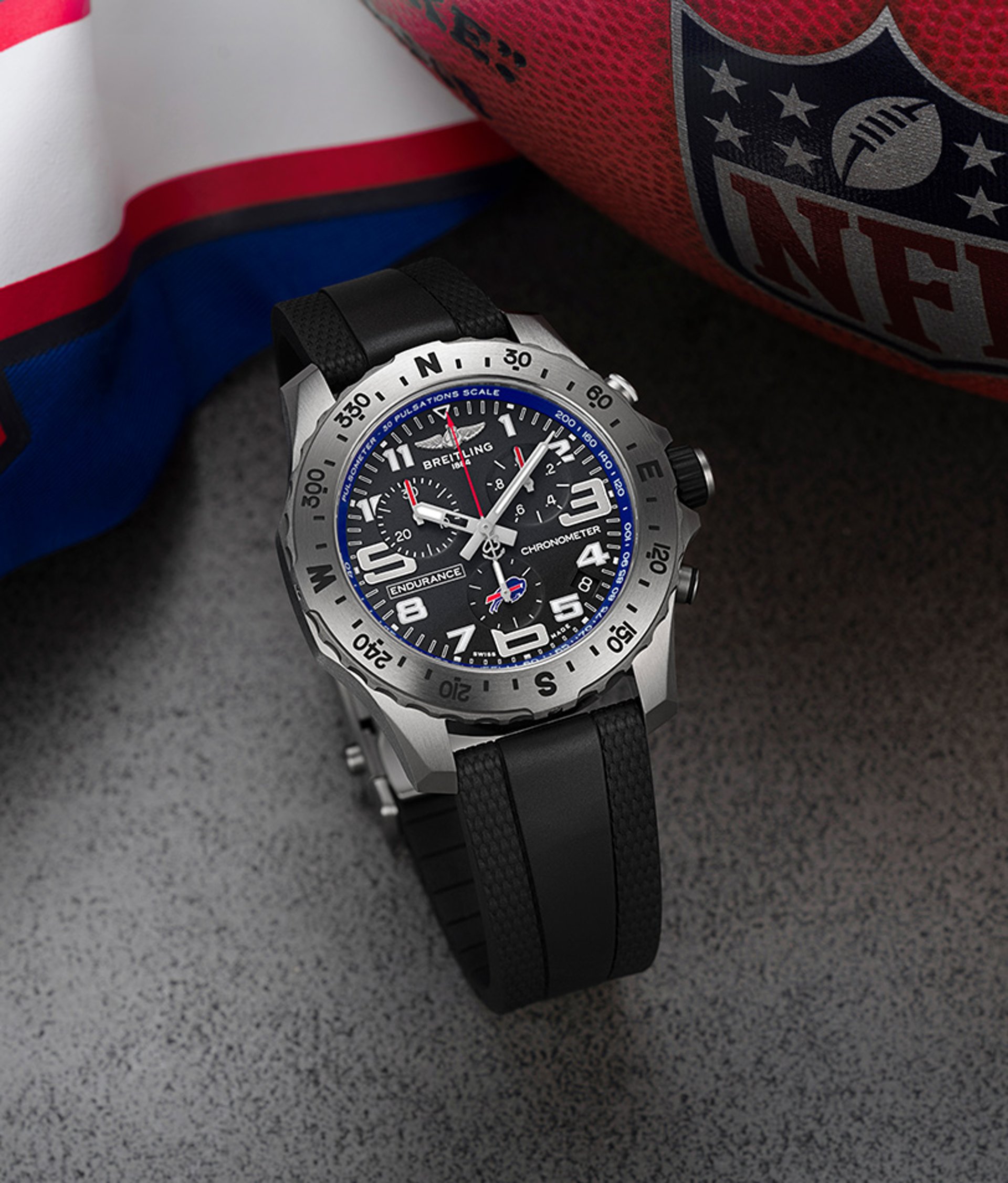 {generated} Breitling Endurance watch with black strap shown beside NFL gear, highlighting its sporty detailing and bold dial.