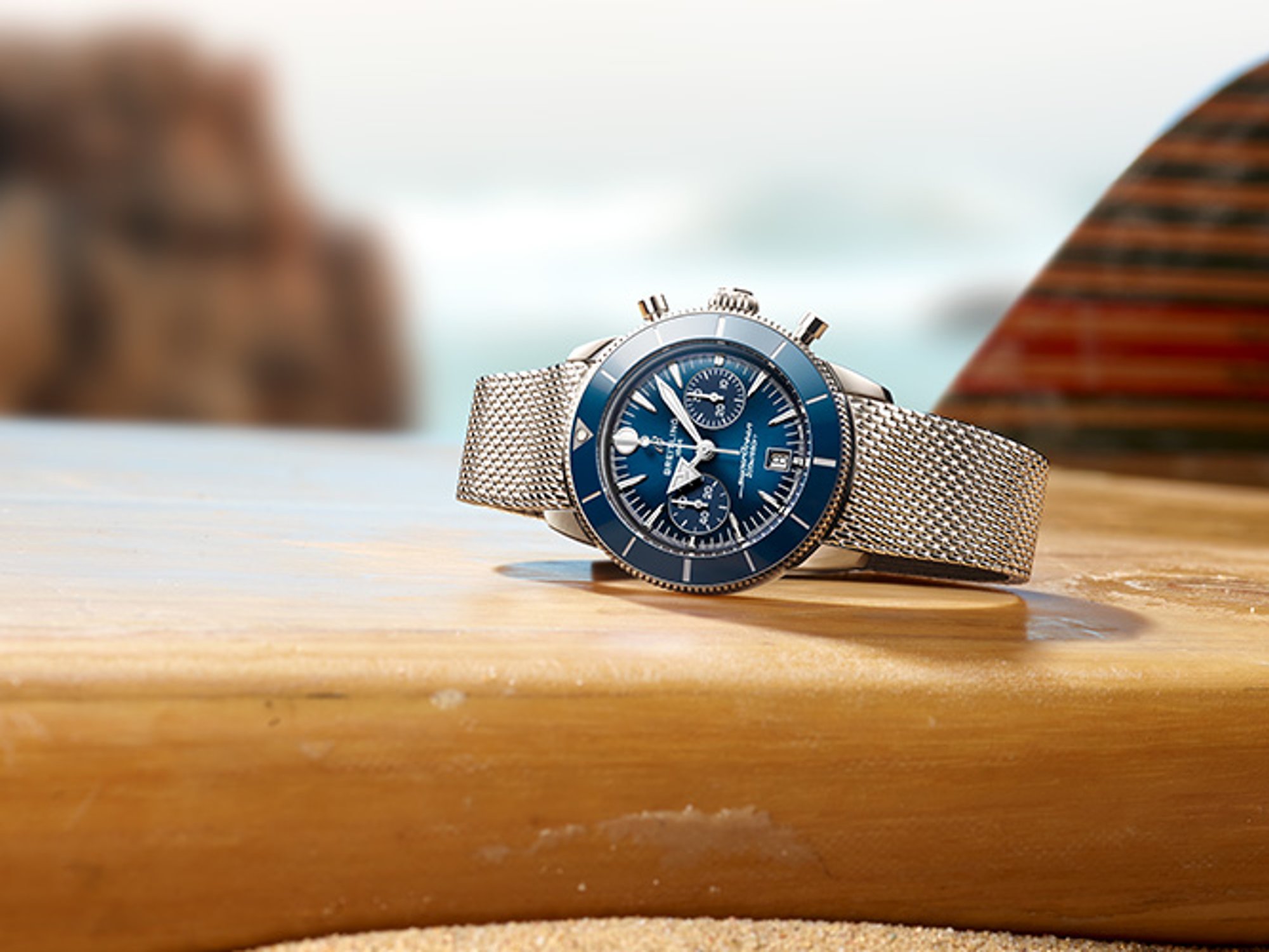 A dark blue Superocean Heritage lies on a table with a magazine and a white rope.