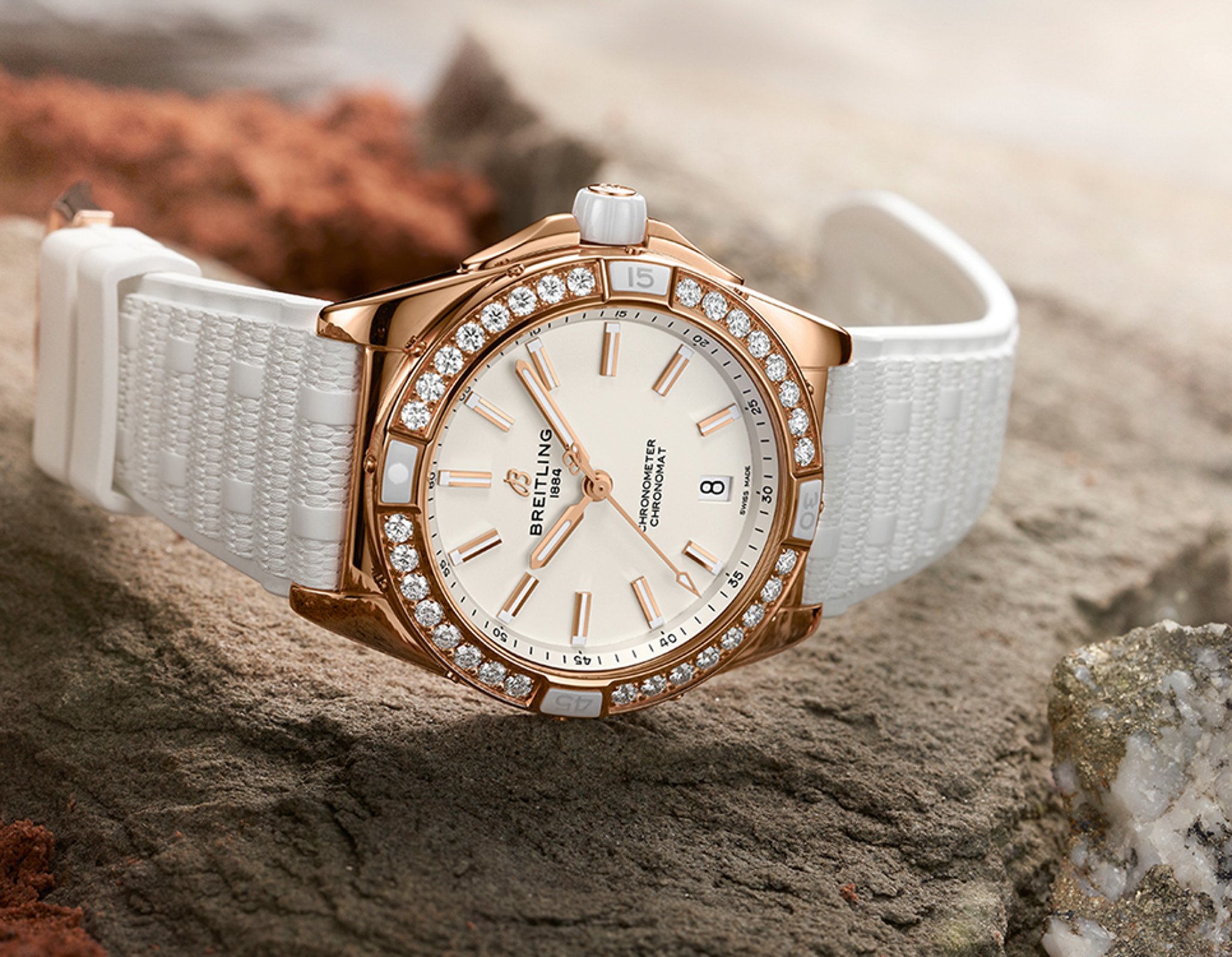 {generated} Breitling Chronomat en or rose avec lunette diamantée et bracelet blanc posé sur pierre pour mettre en valeur son style