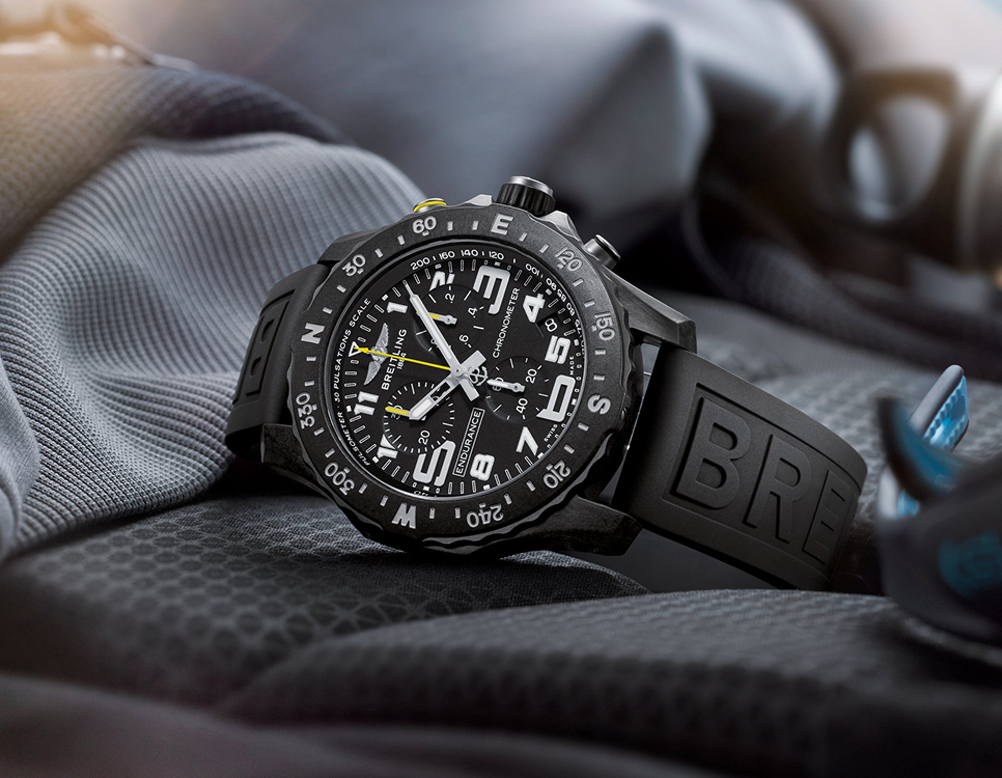 {generated} Breitling Endurance Pro置於科技材質上,呈現黑色錶殼、醒目數字與運動風橡膠錶帶。