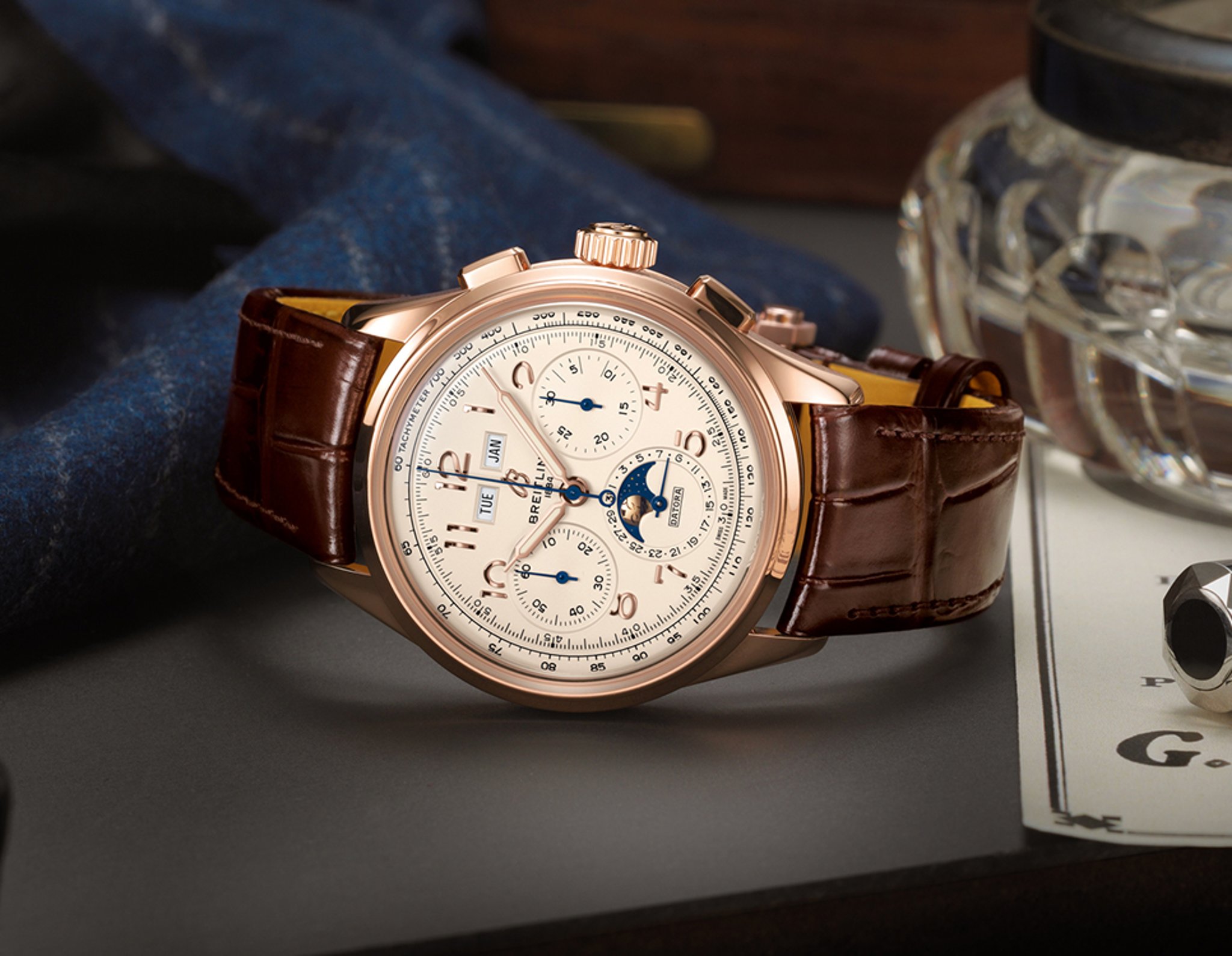 {generated} Breitling Premier watch with rose gold case and brown leather strap presented on a refined desk with moonphase details
