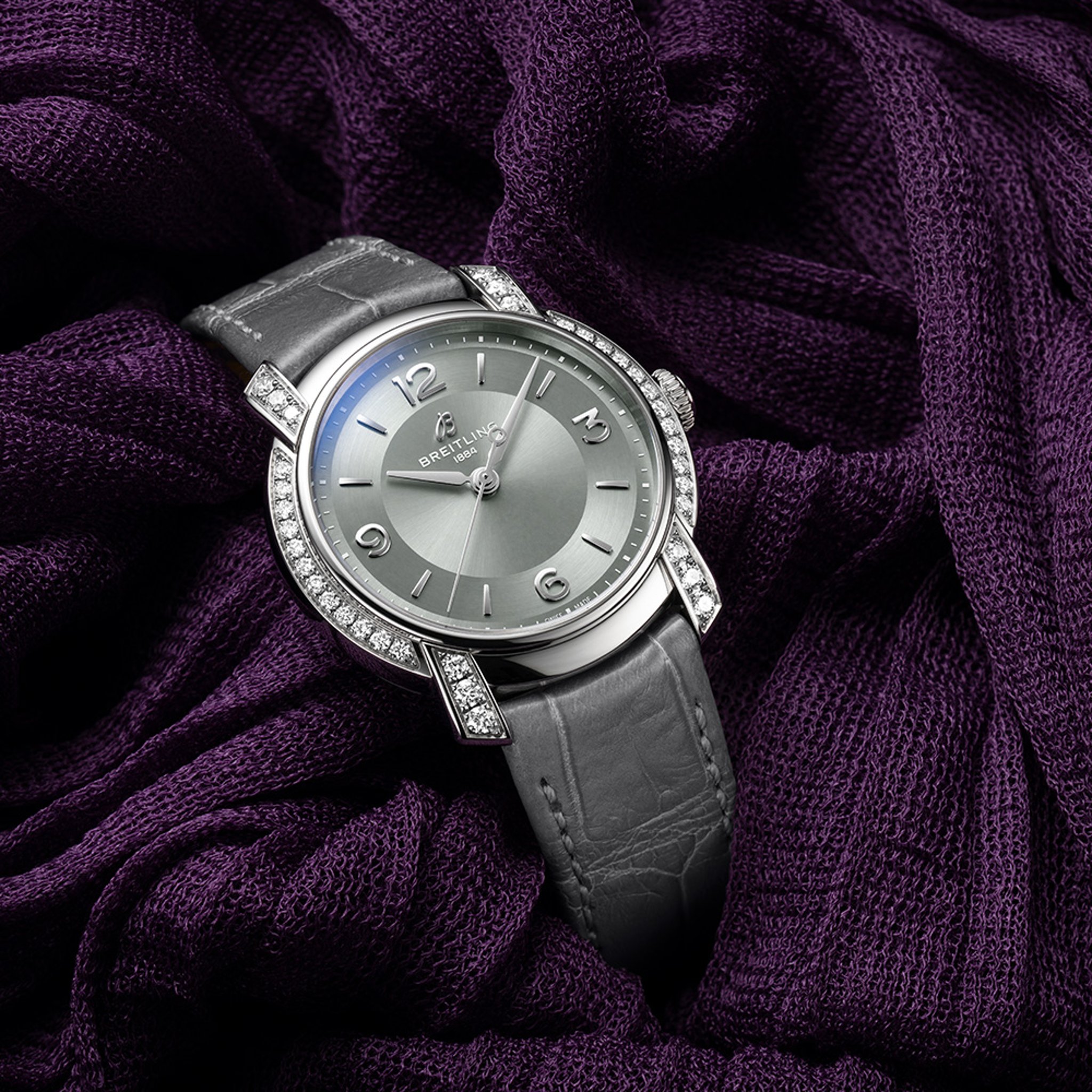 {generated} Breitling Lady Premier A10310671M1P1 en gris con detalles de diamantes sobre tela púrpura intensa para un acabado refinado